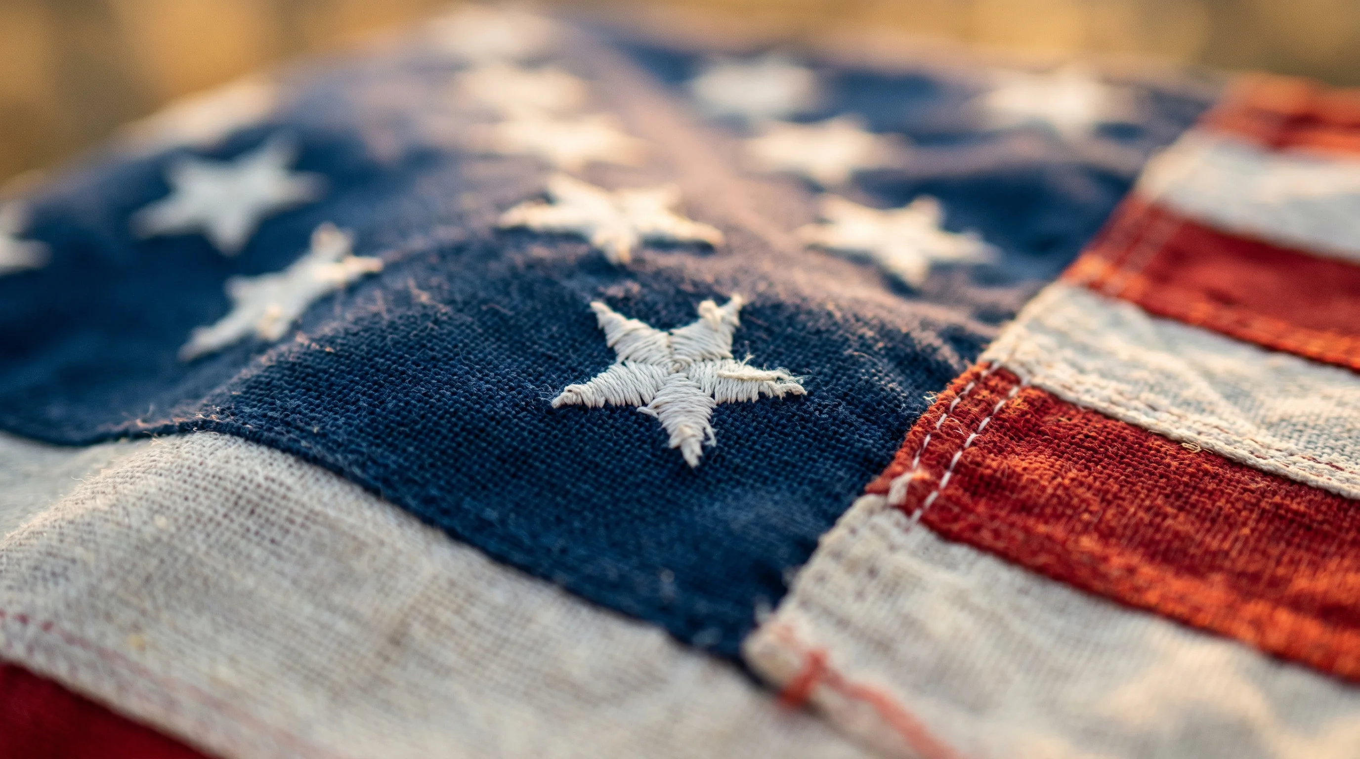 Abstract close-up of U.S. flag fabric texture in warm golden light