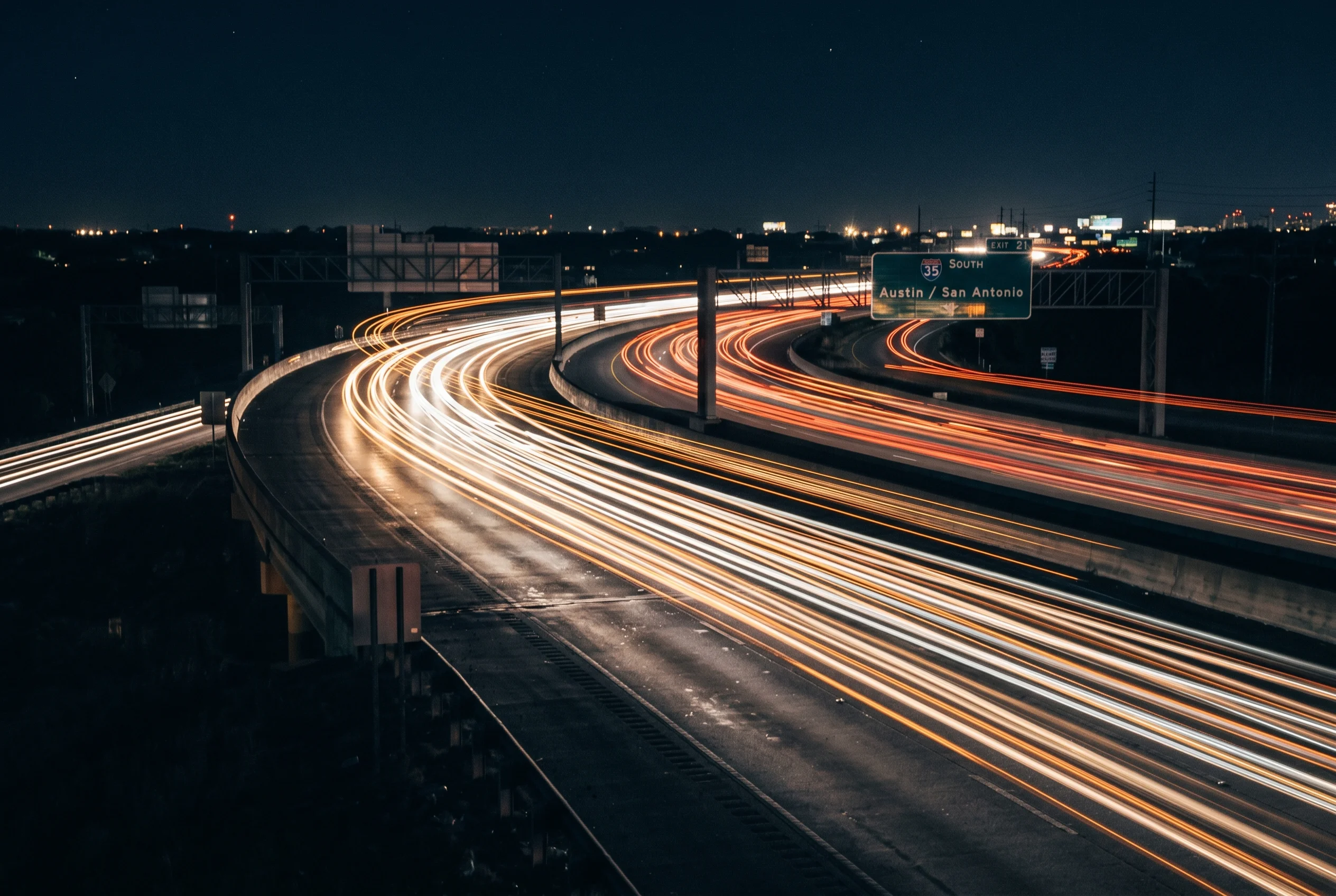 Abstract motion blur of highway light trails at night in Austin, Texas — symbolizing the impact of personal injury cases handled by Austin attorneys